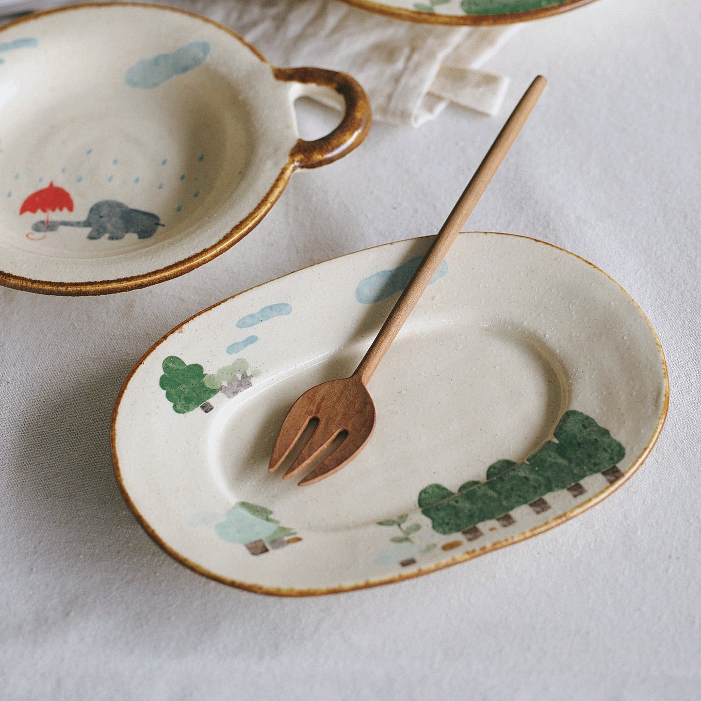 Ceramic tableware set with animal illustrations on a white surface