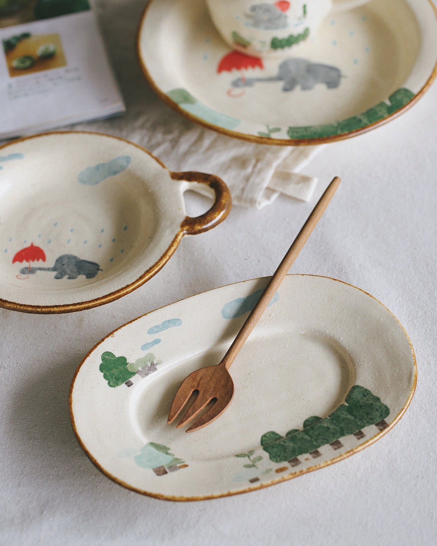 Ceramic tableware set with animal illustrations on a white surface