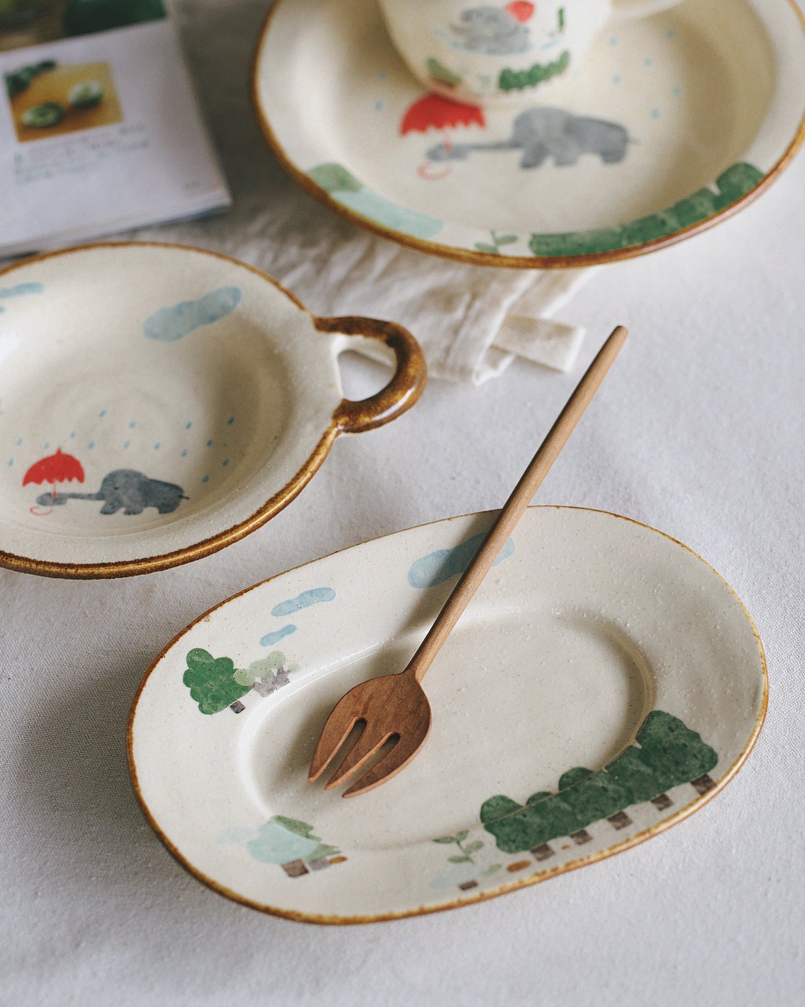 Ceramic tableware set with animal illustrations on a white surface