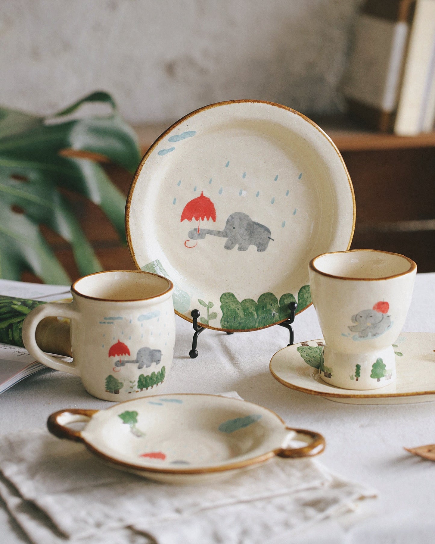 Ceramic tableware set with animal illustrations on a neutral background