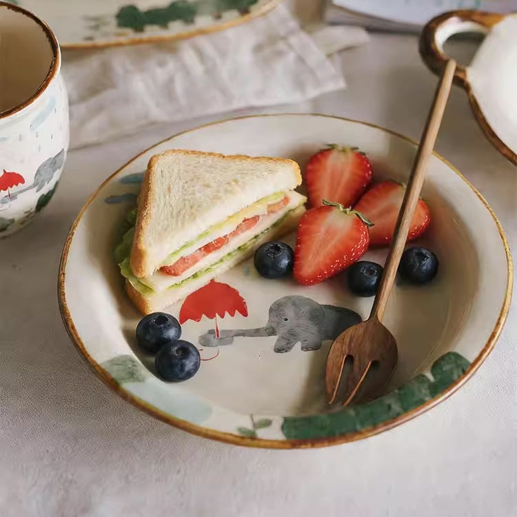 Tea set with a plate of sandwich and fruit on a marble surface