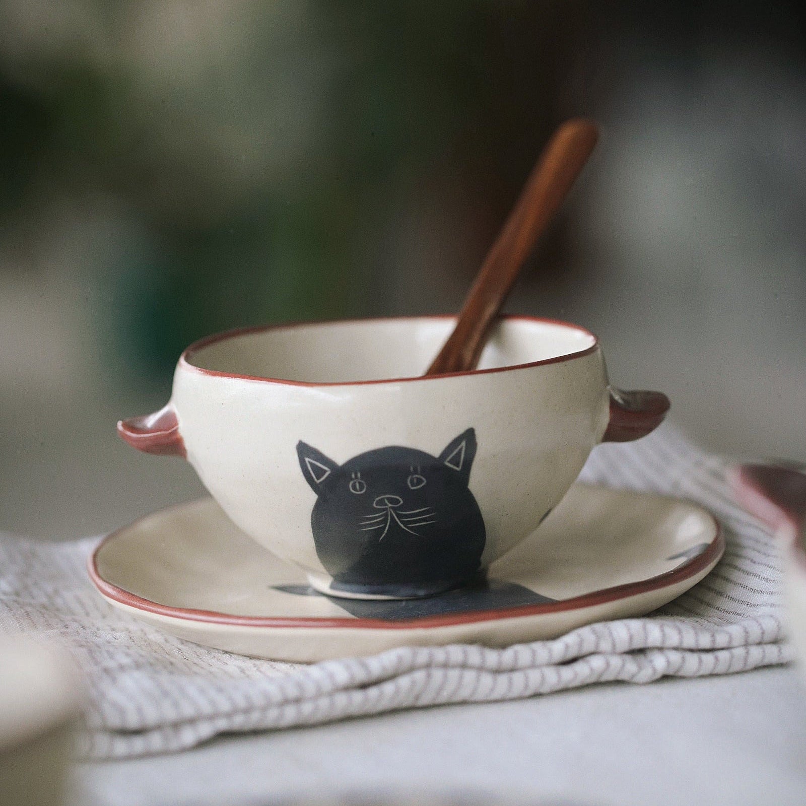 Ceramic bowl with cat design on a white surface