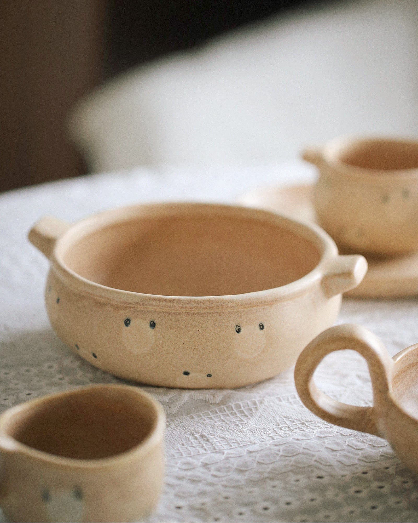 Set of ceramic bowls on a textured surface with a blurred background
