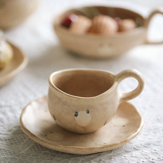 Ceramic cup and saucer with a face on a textured surface