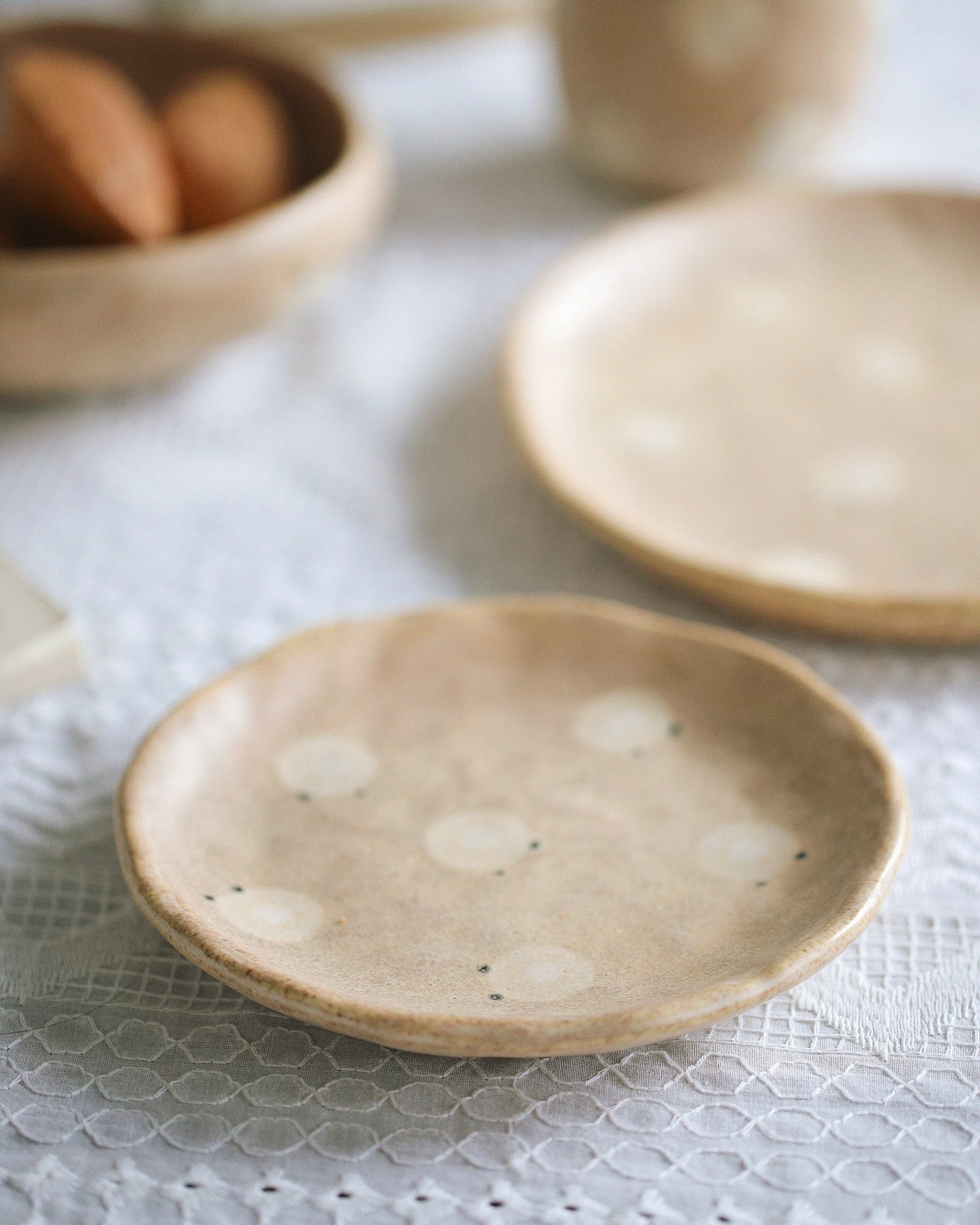 Two ceramic plates on a textured surface with a blurred background