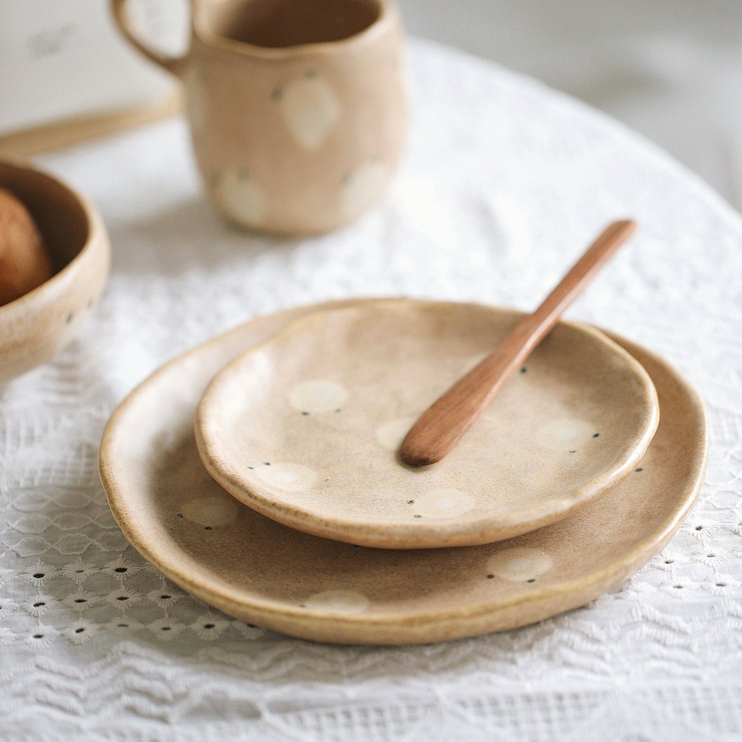 Set of ceramic plates and a cup on a textured surface