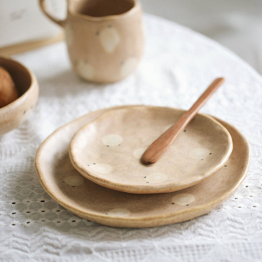 Set of ceramic plates and a cup on a textured surface