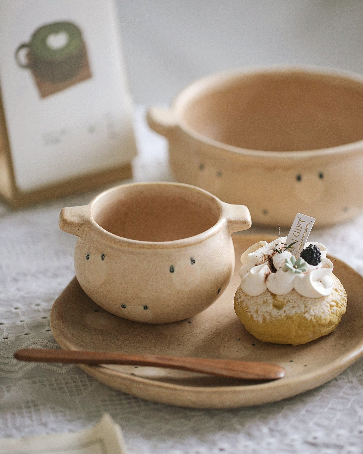 Ceramic cup with handle on a plate with a dessert, on a textured surface.