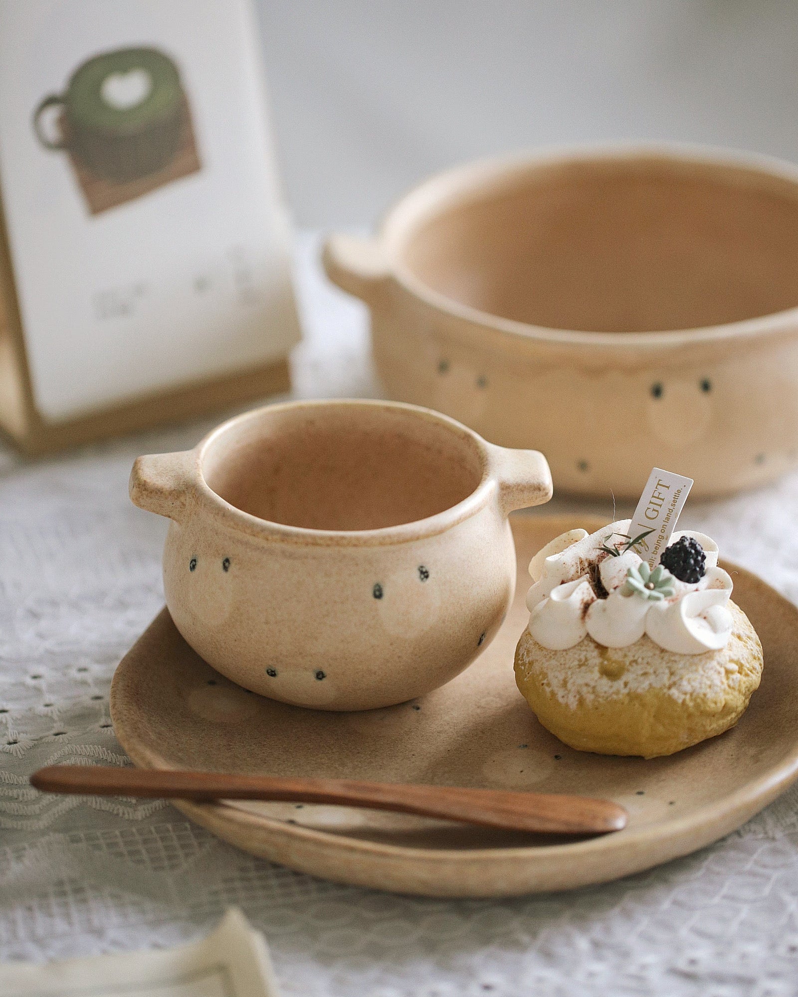 Ceramic cup with handle on a plate with a dessert, on a textured surface.